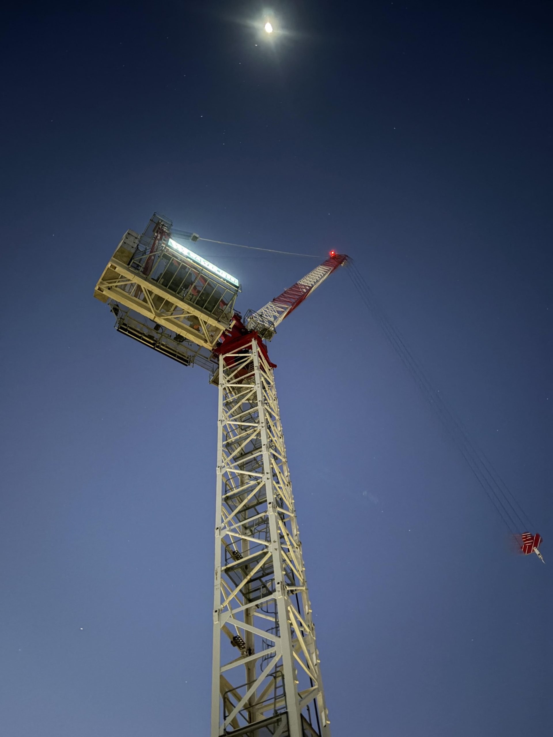 Boland Cranes Potain MCR225A luffing tower crane photographed against the night sky